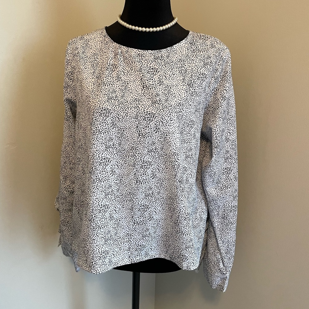 Black and white ruffled and open arm blouse